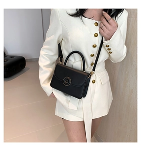 Fashionable black leather mini crossbody bag styled on a white blazer for a chic look