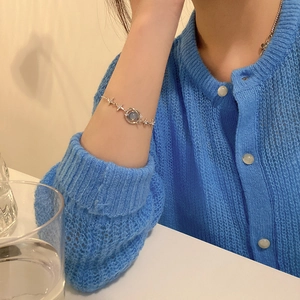 Elegant silver star and planet bracelet with blue opal stone on a woman's wrist