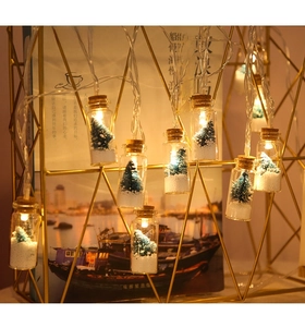 Detail view of mini LED wishing bottles with miniature Christmas trees and faux snow décor