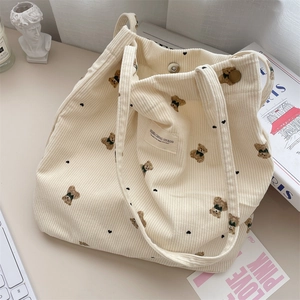 Detail of corduroy tote bag showing soft ribbed texture and cartoon bear print