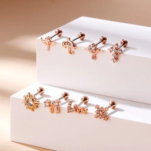 Detailed macro view of 8 rose gold stainless steel cartilage studs with zircon inlays