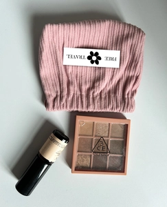 Pink corduroy makeup pouch detail with Free Travel card and beauty accessories