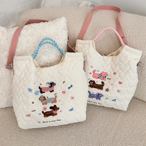 Detail of cartoon animal embroidery and quilted fabric texture on the crossbody bag