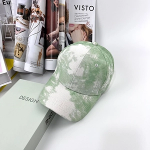 Détail du tissu en velours côtelé tie-dye vert et blanc sur une casquette de baseball