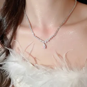 Elegant silver tennis necklace with pear-shaped zircon pendant on model with feathers