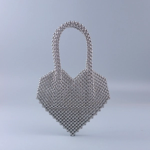 Dettaglio della borsa a mano con perline a forma di cuore argento e finitura metallica
