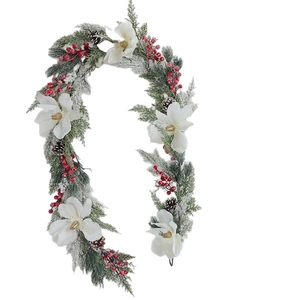 Christmas garland with white magnolias, red berries, pinecones and snowy pine needles