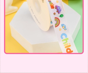 Close-up of white decorative ribbon with colorful rainbow, car, and balloon patterns