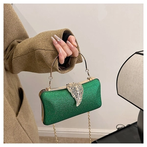 Close-up of green glitter evening bag featuring a gold leaf clasp with rhinestones