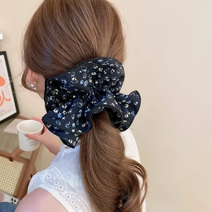 Floral print oversized bow hair scrunchie shown styled on a ponytail back view