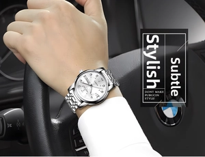 Detail of silver men's watch with Roman numerals and calendar on a stainless steel band