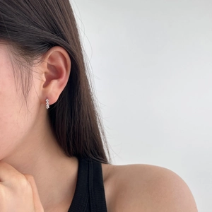 Close-up of S925 sterling silver earrings with three vertical white zircon stones on ear