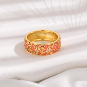 Detail of coral pink enamel ring with golden leaf texture and white zircon accents