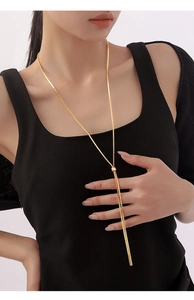 Adjustable golden lariat snake chain necklace on model in a sleek minimalist style