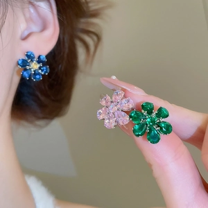 Close-up of pear-cut zircon flower earrings in royal blue, pink, and emerald green