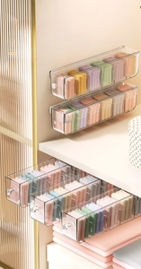 Macro detail of wall-mounted clear acrylic storage drawer with crystal handle and dividers