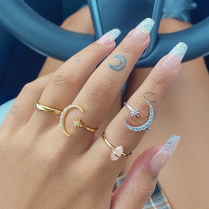 Detailed view of sterling silver star and moon rings with crystals on model's hand