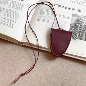 Close-up of burgundy faux leather magnetic eyewear clip holder with snap button detail