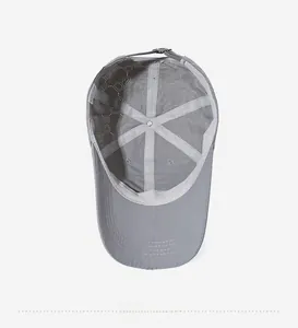 Detailed interior of the grey baseball cap showing breathable holes and adjustable metal buckle
