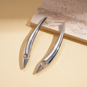 Gros plan de boucles d'oreilles courbées en métal argenté avec découpe sur pierre