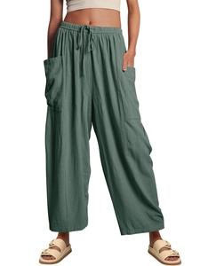 Detail of green linen wide-leg pants featuring elastic drawstring waist and large side pockets