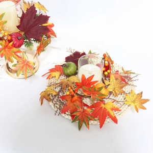Autumn candle ring with artificial maple leaves, mini pumpkins and berries for Halloween decor