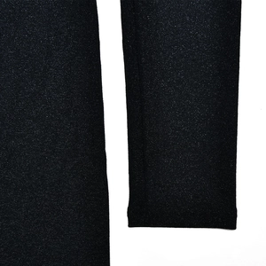 Close-up of the black elastic knitted fabric texture and hem detail of the dress