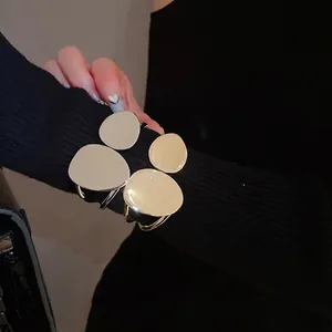 Irregular oval double-layer gold and silver cuff bracelet with a modern geometric design