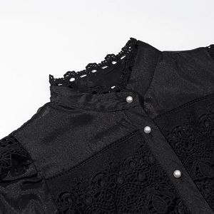 Detail of elegant black dress showing lace trim, stand collar, and pearl buttons