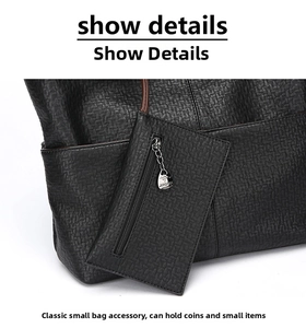 Detail of black embossed leather tote featuring a zipper pouch and metal kangaroo charm