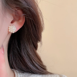 Gros plan de boucles d'oreilles fleurs en perles portées par un mannequin avec douceur