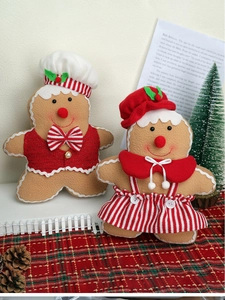 Detail of plush gingerbread man and girl dolls with chef hat and striped dress decor