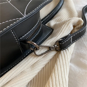 Schwarze PU Leder Umhängetasche Detail mit weißer Naht, eleganter Metall Karabiner.