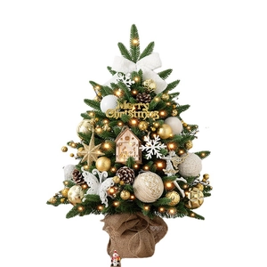 Mini tabletop Christmas tree with warm lights, gold ornaments, and burlap base decor