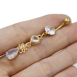 Gros plan détaillé du piercing de nombril doré avec cristaux de zircone blancs en fleur