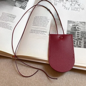 Close-up of a burgundy faux leather magnetic glasses holder pendant on a magazine