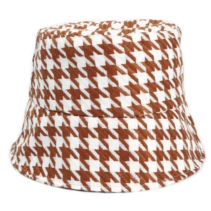 Detail of the brown and white houndstooth pattern on a thick knit bucket hat for winter