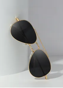 Classic aviator sunglasses with gold metal frame and dark polarized lenses on white prop