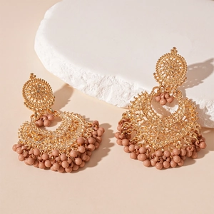 Detail of vintage bohemian fan earrings with gold filigree and small pink beaded tassels