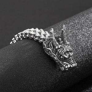 Macro detail of retro silver stainless steel dragon head pendant and thick chain