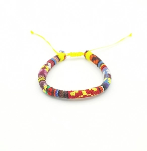 Close-up of colorful handmade bohemian woven cotton bracelet with adjustable knot