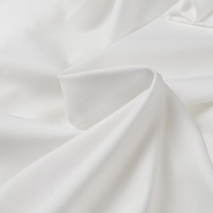 Vue détaillée de la texture du textile blanc et du drapé fluide du tissu