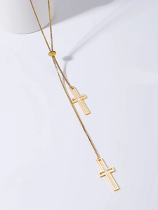 Detailed shot of golden box chain necklace featuring sliding bead and hollow cross pendants