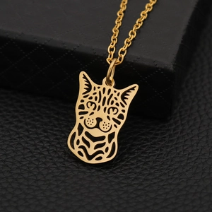 Elegant gold hollow cat pendant necklace with a delicate chain over a black jewelry box
