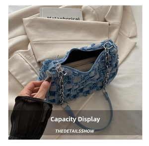 Internal capacity of denim shoulder bag featuring blue plaid weaving and frayed edges