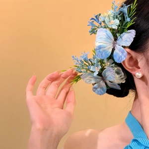 Détail de la pince à cheveux papillon bleu et fleurs sur une coiffure élégante