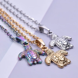 Minimalist turtle pendant necklaces in silver, gold, and rainbow stainless steel finishes