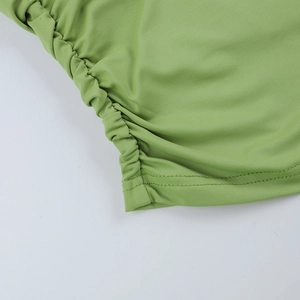 Gros plan détaillé sur le tissu tricoté élastique vert herbe avec coutures plissées