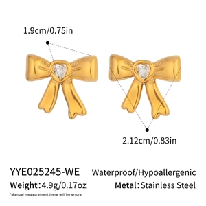 Detail view of gold bow earrings with heart zircon and size measurements