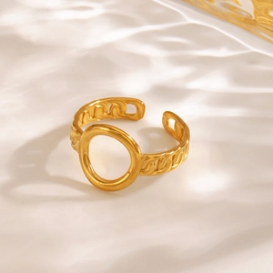 Golden stainless steel chain ring with oval hollow design on wavy white background